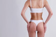 © Evrymmnt - Close up shot of unrecognizable fit woman in lingerie isolated on white background. Cropped shot of lower half of slim attractive female's body in white underwear. Copy space for text.