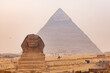 © takepicsforfun - View of Sphinx in The Giza Plateau with The Great Pyramid of Giza in the background.