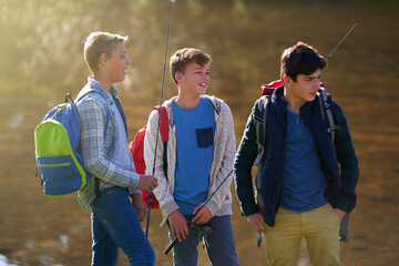 Lets get fishing. Shot of a group of young boys fishing by a lake.