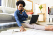 © Wavebreak Media - Mid adult african american freelancer with laptop talking on smartphone and examining documents