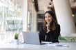 © Wasan - Portrait of a business woman working with a laptop on a desk in a spacious office. Looking at camera.