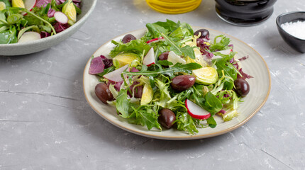 Fresh green vegan salad from green leaves mix vegetables and olives. 