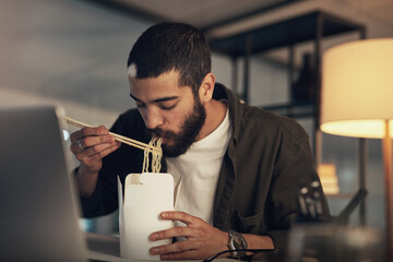 Fototapete - Business gets better with every bite. Shot of a young businessman having takeout and using a laptop during a late night at work.
