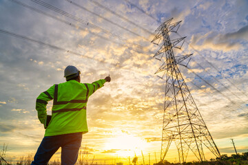 Wall Mural - asian electrical engineer standing and watching at the electric power station to view the planning w