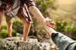 © Ruan Jordaan/peopleimages.com - Alone we climb rocks, together we climb mountains. Cropped shot of hikers helping each other climb up a rock in nature.