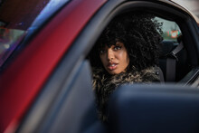 Portrait Of A Woman In A Red Sports Car Looking Into Camera.