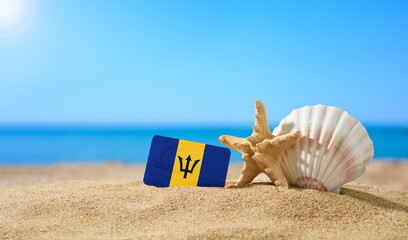 Wall Mural - Tropical beach with seashells and Barbados flag. The concept of a paradise vacation on the beaches of Barbados.