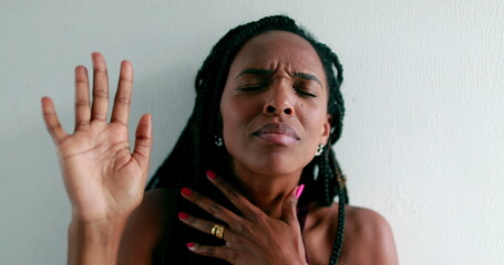 Black woman praying to God, african female raising arms to sky seeking guidance