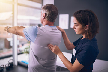 Aufkleber - Just a little more. Cropped shot of a young female physiotherapist treating a mature male patient.