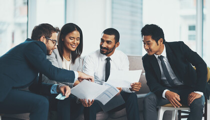 Aufkleber - We think wiser when were together. Shot of a group of businesspeople discussing paperwork while sitting together.