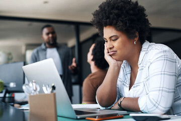 Poster - Do I really have to do this. Shot of a young businesswoman using a laptop and looking annoyed in an office.