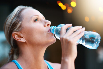 Sticker - Nothing tastes better than water after an intense workout. Shot of a mature woman drinking water out of a bottle outdoors.