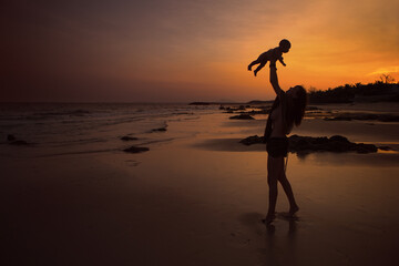 Silhouette of an Indian family enjoying in the beach during sunset