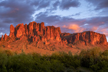 Stunning Red Sunset Of The Superstition Mountains With Purple And Orange Clouds.