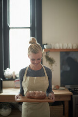 Sticker - The perfect loaf. Shot of a young female baker with homemade bread.