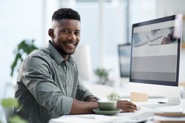 Poster - Great start to the day. Shot of a young businessman working on a computer in an office.