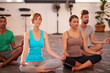 © Daniel L/peopleimages.com - Concentrating on a healthier lifestyle. A group of people doing yoga together.