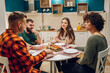 © Zamrznuti tonovi - Group of friends enjoying dinner while sitting at the kitchen table together
