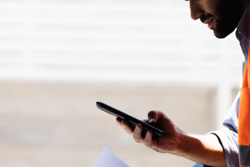 a portrait of an industrial man engineer with smartphone in a factory, working.