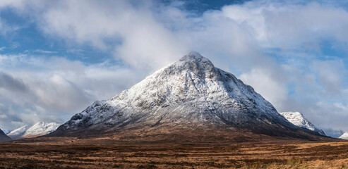 Beautiful iconic landscape Winter image of Stob Dearg Buachaille Etive Mor mountain in Scottish Highlands againstd vibrant blue sky