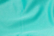 Fabric for sports clothing in a green color, the texture of a football shirt jersey, and a textile background