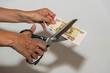 hand with scissors cutting Russian ruble