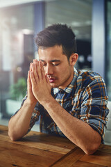 Sticker - Seeking out some guidance and strength. Shot of a young designer sitting in an office with his hands clasped in prayer.