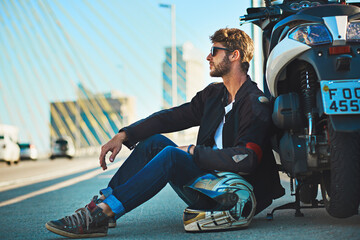 Wall Mural - Every ride is an adventure. Shot of a young man riding a motorbike through the city.