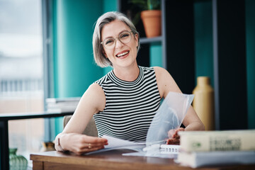 Wall Mural - You have what it takes to succeed. Shot of of a mature businesswoman working on paperwork in her office.