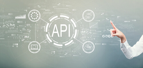 api - application programming interface concept with hand pressing a button on a gray background
