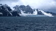 Glacier meeting the Southern Ocean at the base of a rugged mountain in Antarctica