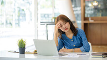 Asian Women Sitting In An Office With Stress And Eye Strain Tired, Portrait Of Sad Unhappy Tired Frustrated Disappointed Lady Suffering From Migraine Sitting At The Table, Sick Worker Concept.