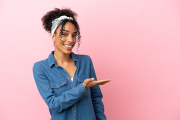 Sticker - Young latin woman isolated on pink background presenting an idea while looking smiling towards