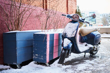 A Lone Abandoned Old Rare Moped Covered In A Layer Of Snow. Moped In Winter City Near Red Brick Wall