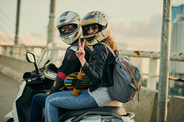 Aufkleber - Getting around town in a fun way. Cropped shot of a young attractive couple riding a scooter around town.