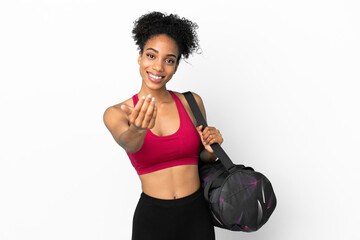 Wall Mural - Young sport african american woman with sport bag isolated on blue background inviting to come with hand. Happy that you came