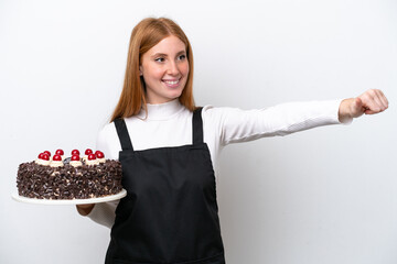 Wall Mural - Young redhead woman holding birthday cake isolated on white background giving a thumbs up gesture