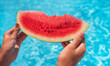 © Sergey - piece of watermelon in female hands at the pool