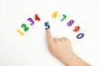 © Olga - The child uses his index finger to move the number five up. Early education. We learn colors and count from zero to ten