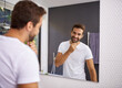 © Lyndon Stratford/peopleimages.com - I do look good with a beard though. Cropped shot of a handsome man looking at himself in the mirror whilst touching his beard at home.