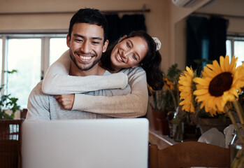 Wall Mural - I hope Im not disturbing.... Shot of a man using his laptop while his girlfriend embraces him from behind.