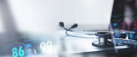 Medical technology background. Doctor's stethoscope and laptop computer with patient monitor, vital signs report, medical network connection with modern virtual screen, health technology