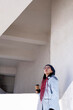 © Дарья Колпакова - Young Asian girl eco-friendly . Reusable glass for hot drink. Walk on the street.