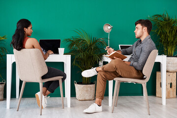 Poster - Coming together to bounce some brilliant ideas off each other. Shot of two young designers having a discussion in an office.