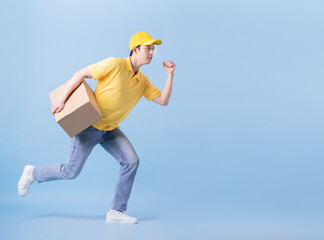 Wall Mural - Full length image of Asian delivery man on blue background