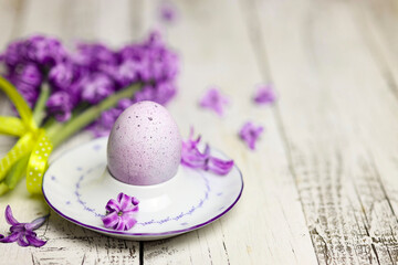 Easter composition with egg and egg cup with Hyacinth spring flowers on wooden background