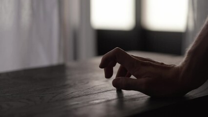 Canvas Print - Slow motion man hand finger tapping on black oak table with copy space