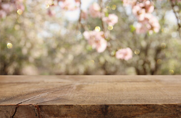 wooden table in front of spring blossom tree landscape. Product display and presentation