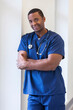 Smiling portrait of young African American male nurse wearing scrubs medical clinic