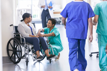 african american patient and nurse with medical staff in hospital corridor